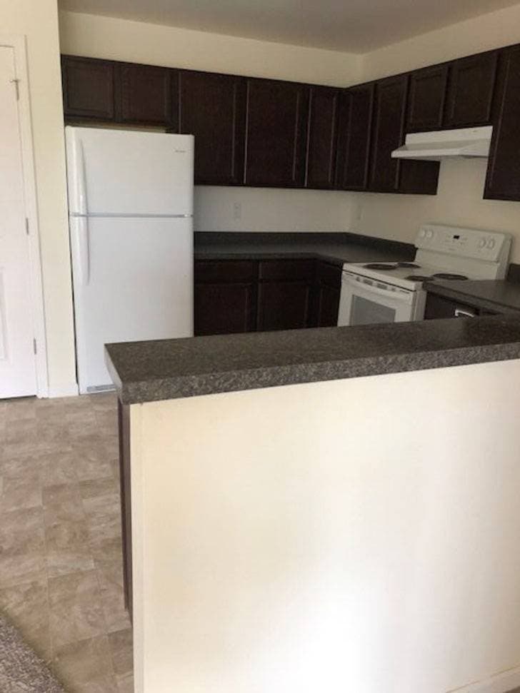 Kitchen counter view with fridge and cabinets